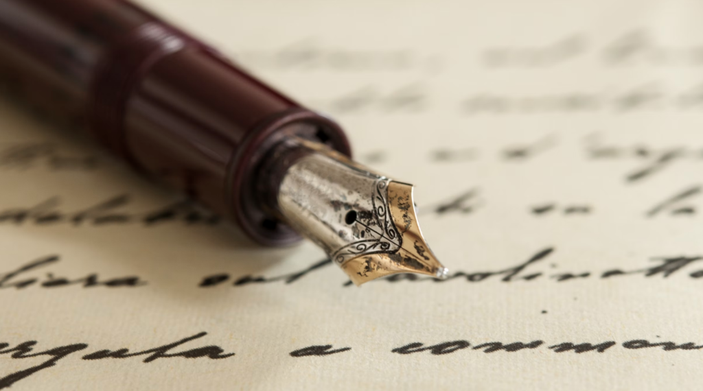fountain pen on top of a piece of paper covered in old fashioned handwriting