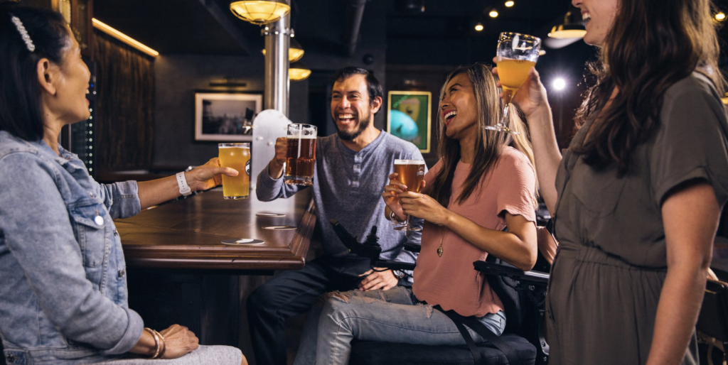 a man and three women in a bar holding alcoholic drinks