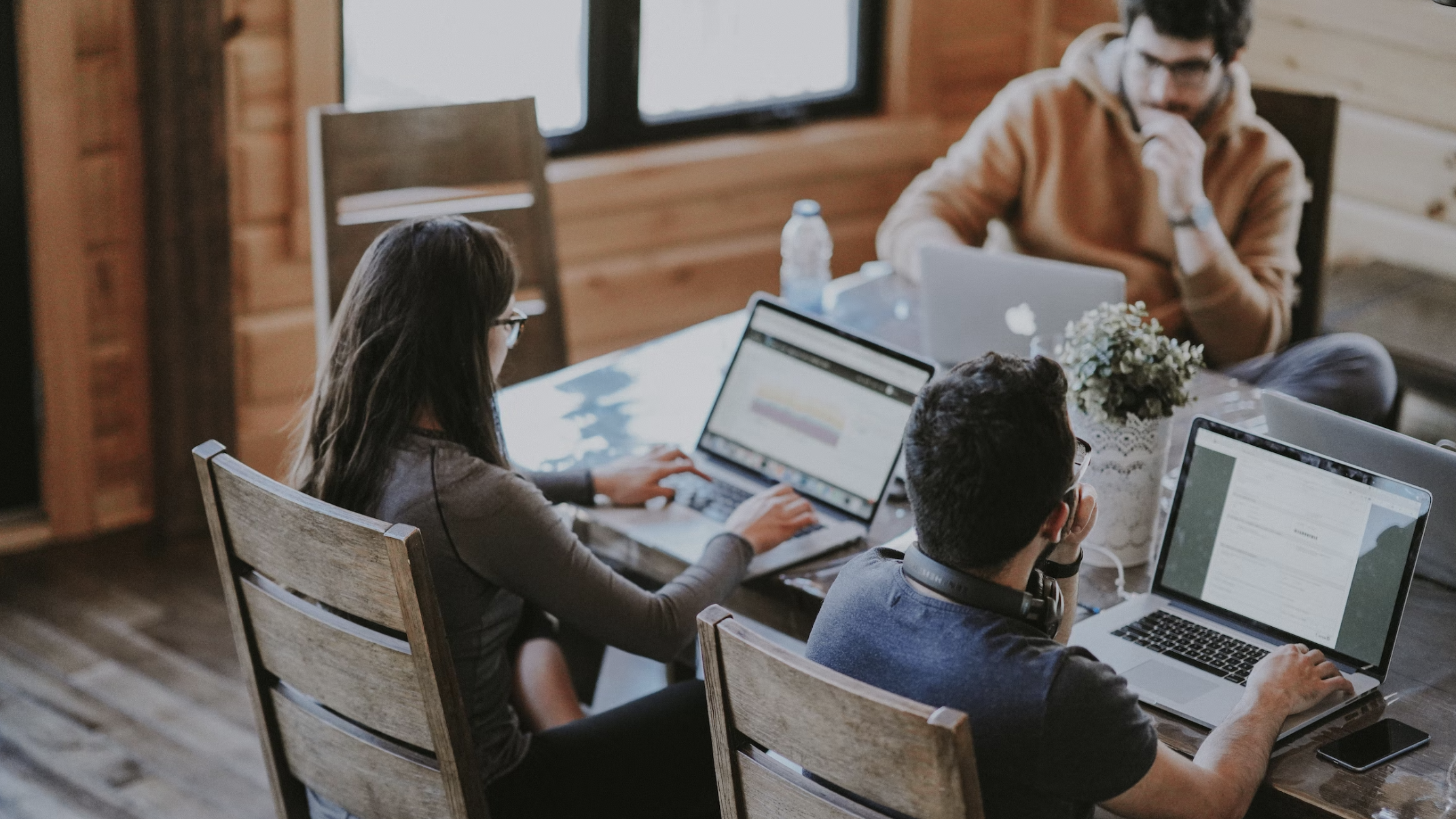 Dyslexia at work: three people wearing casual clothes sat at a table using laptops