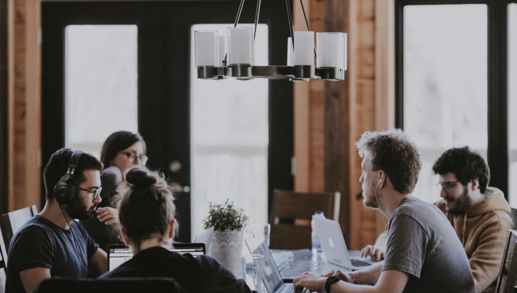 a group of workers in headphones in a shared working space 