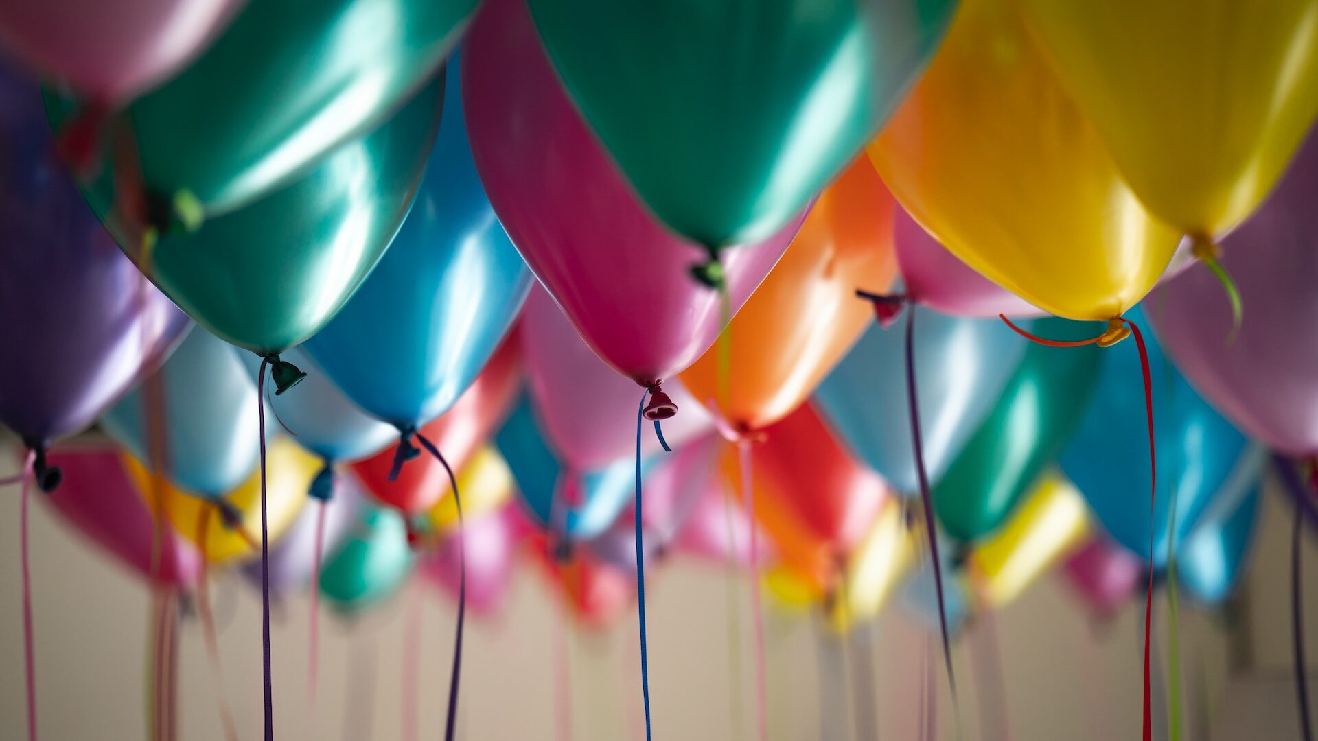 Coloured balloons with trailing strings in selective focus