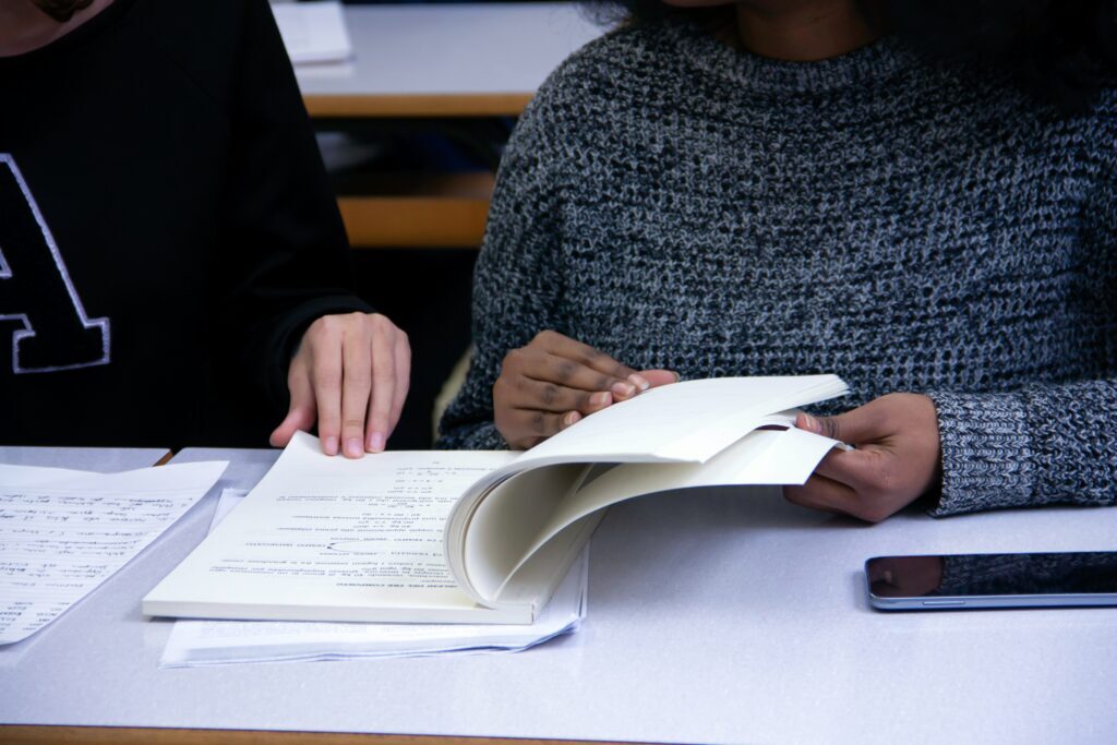 a close-up of two people sharing a textbook