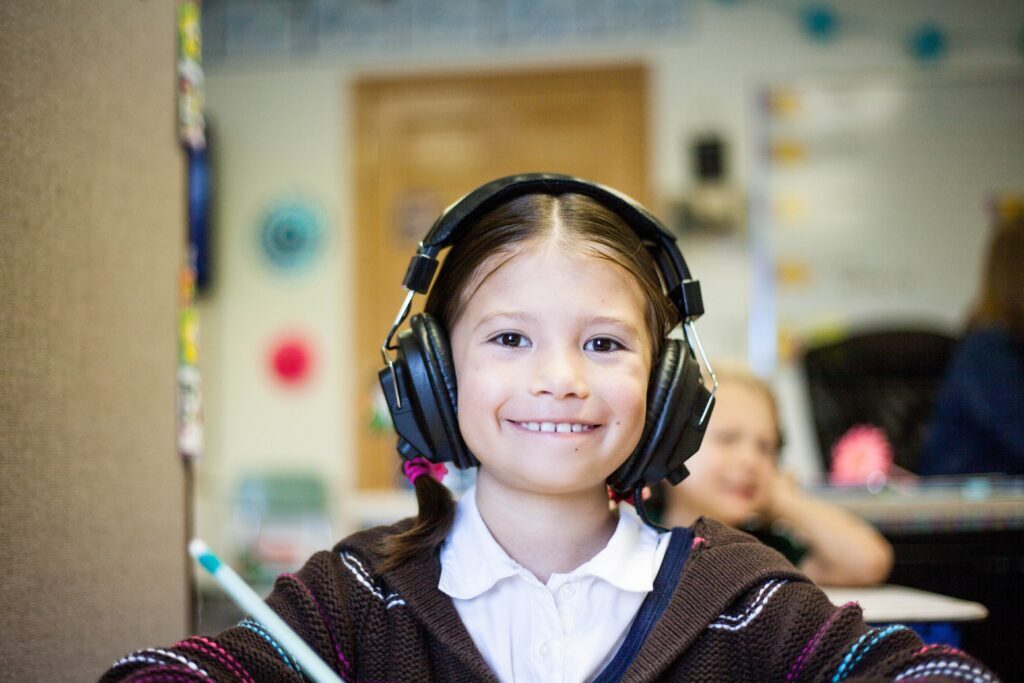 A child with pigtails wearing headphones
