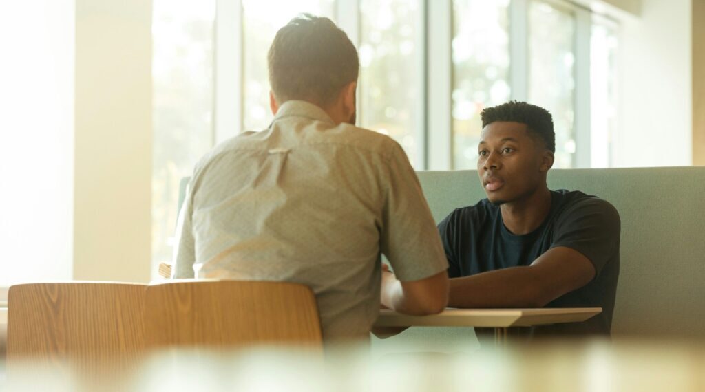 Colleagues sitting, having a discussion over a wooden table
