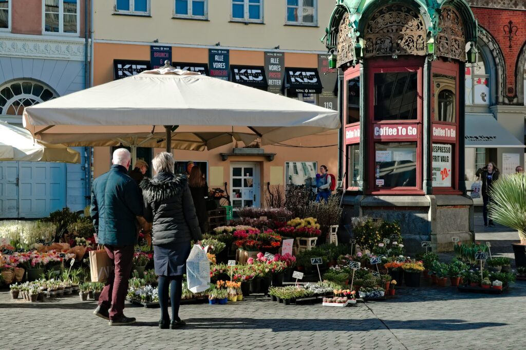 Two older people looking at a flower market 