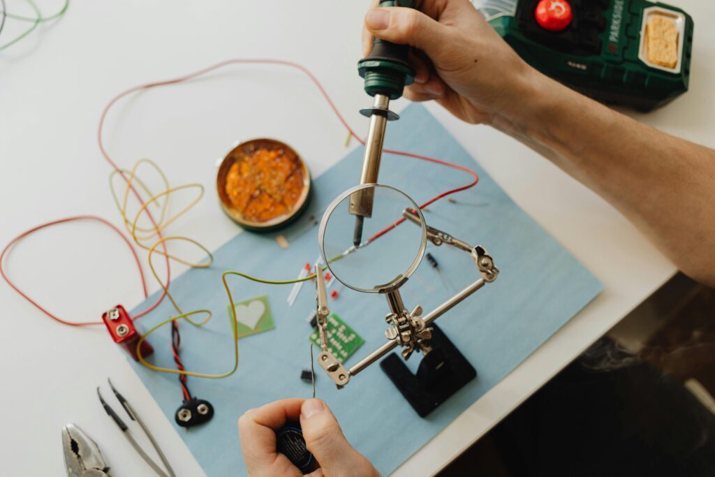 Somebody working with circuitry using a desk magnifier 
