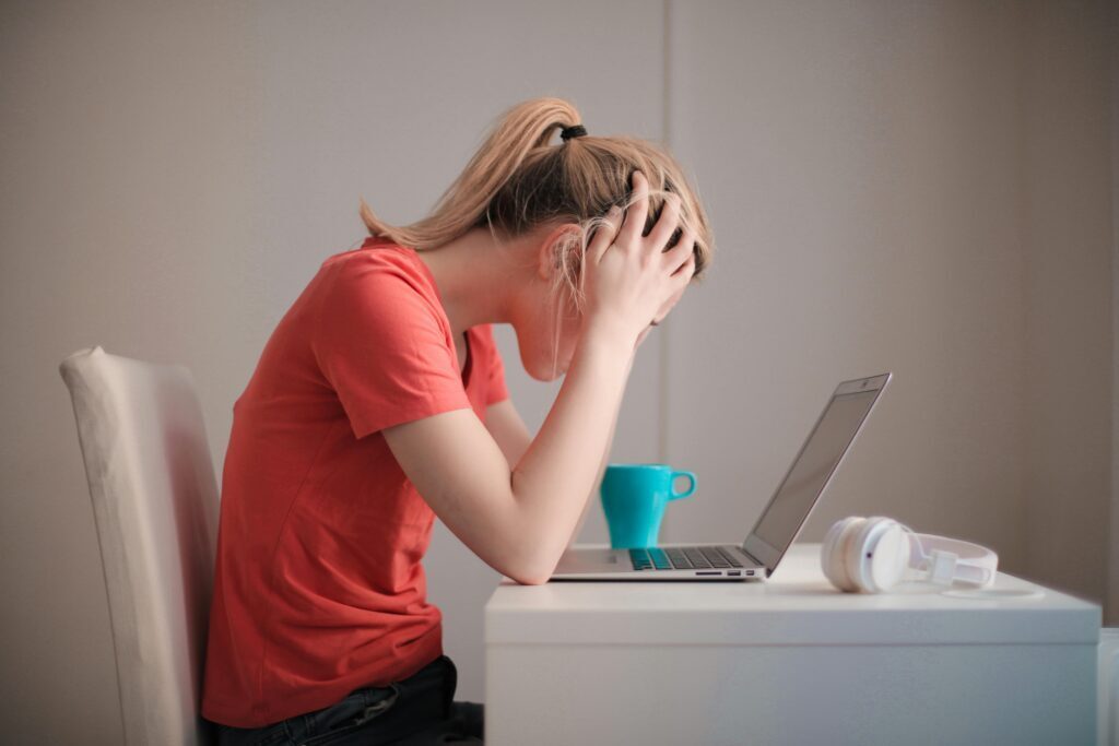 student with their head in their hands at a desk