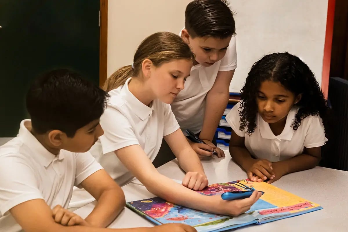 a group of children using a reading pen