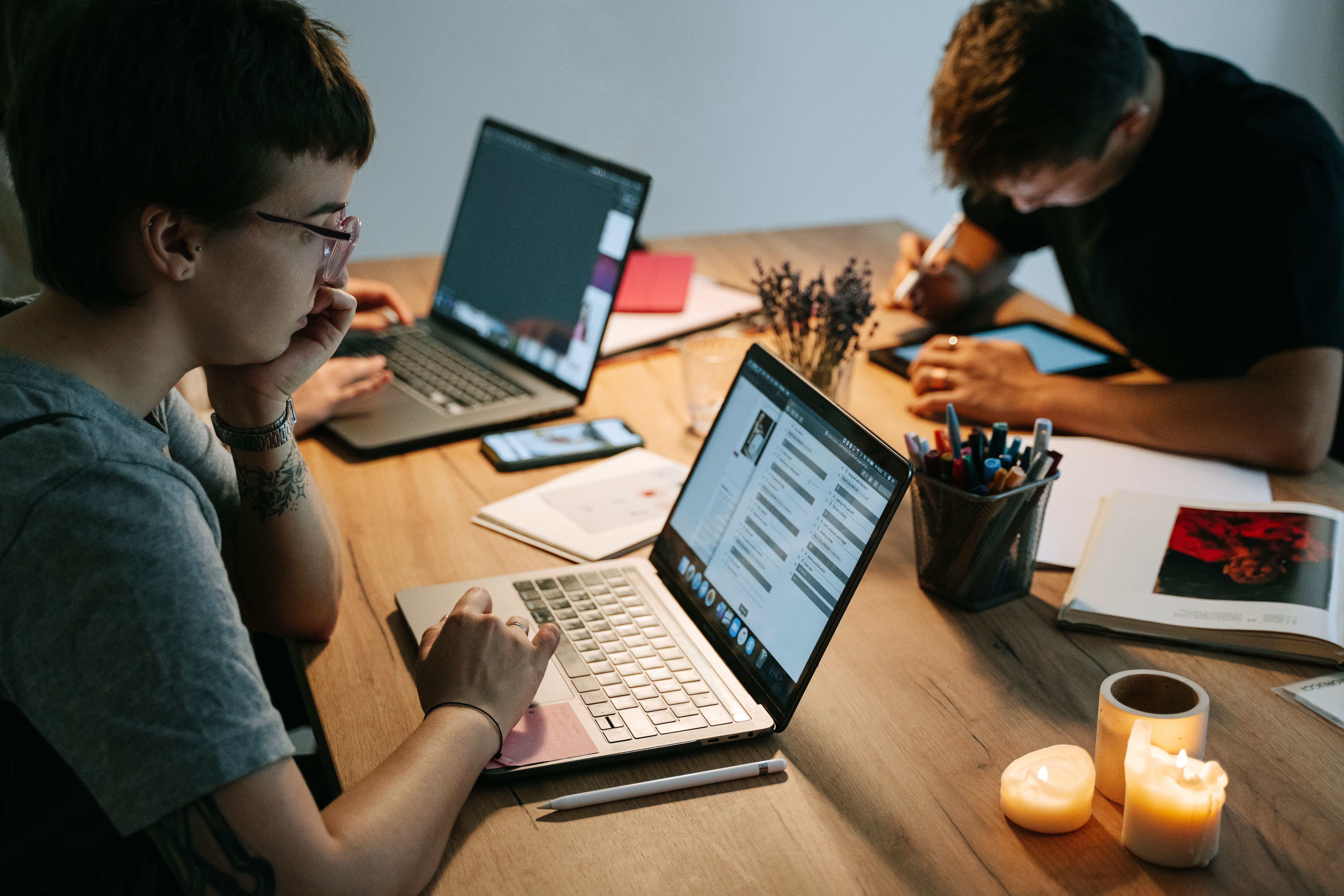 people working on laptop computers at a desk