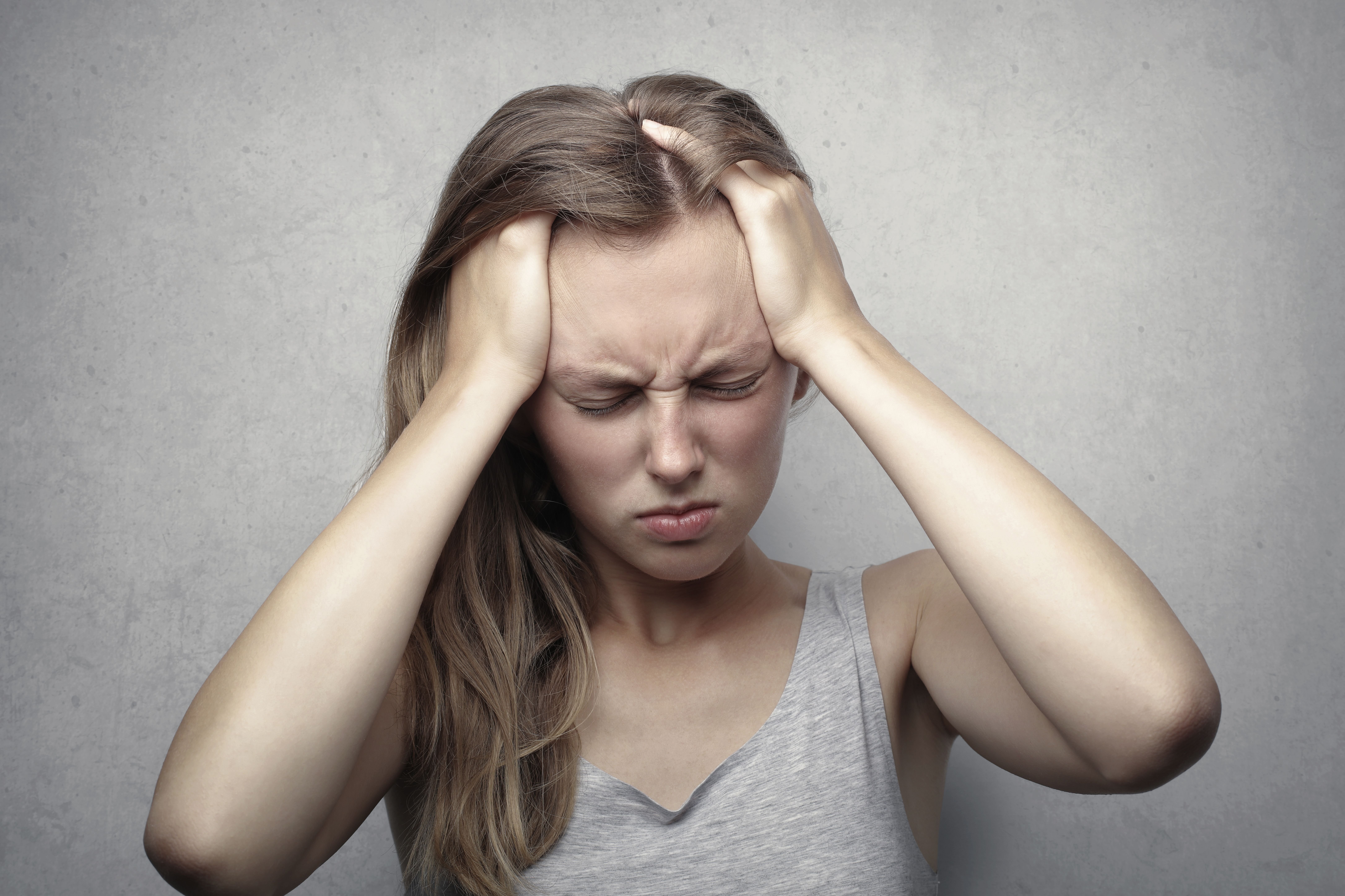 young girl with both hands on her head