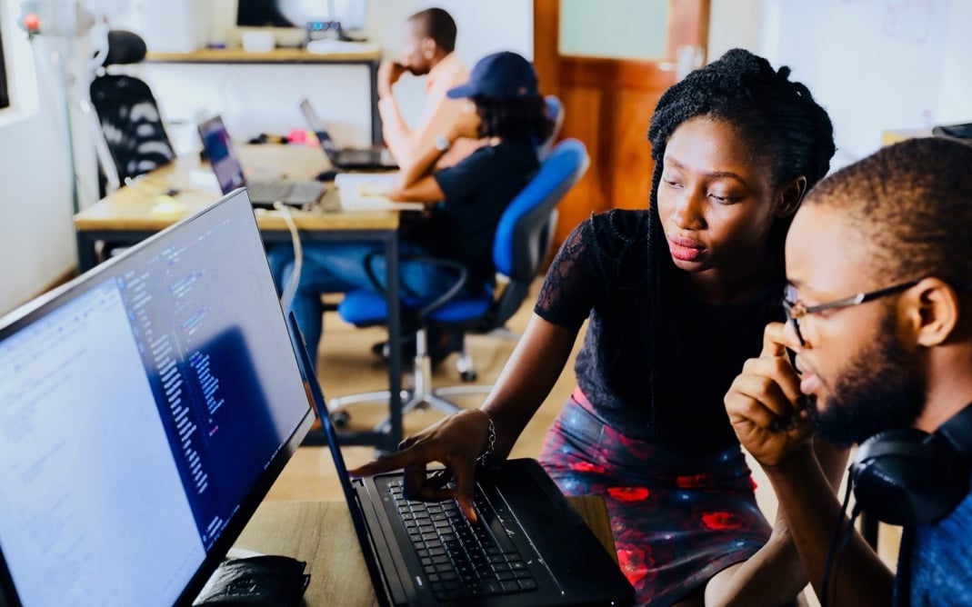 Woman helping man at a laptop
