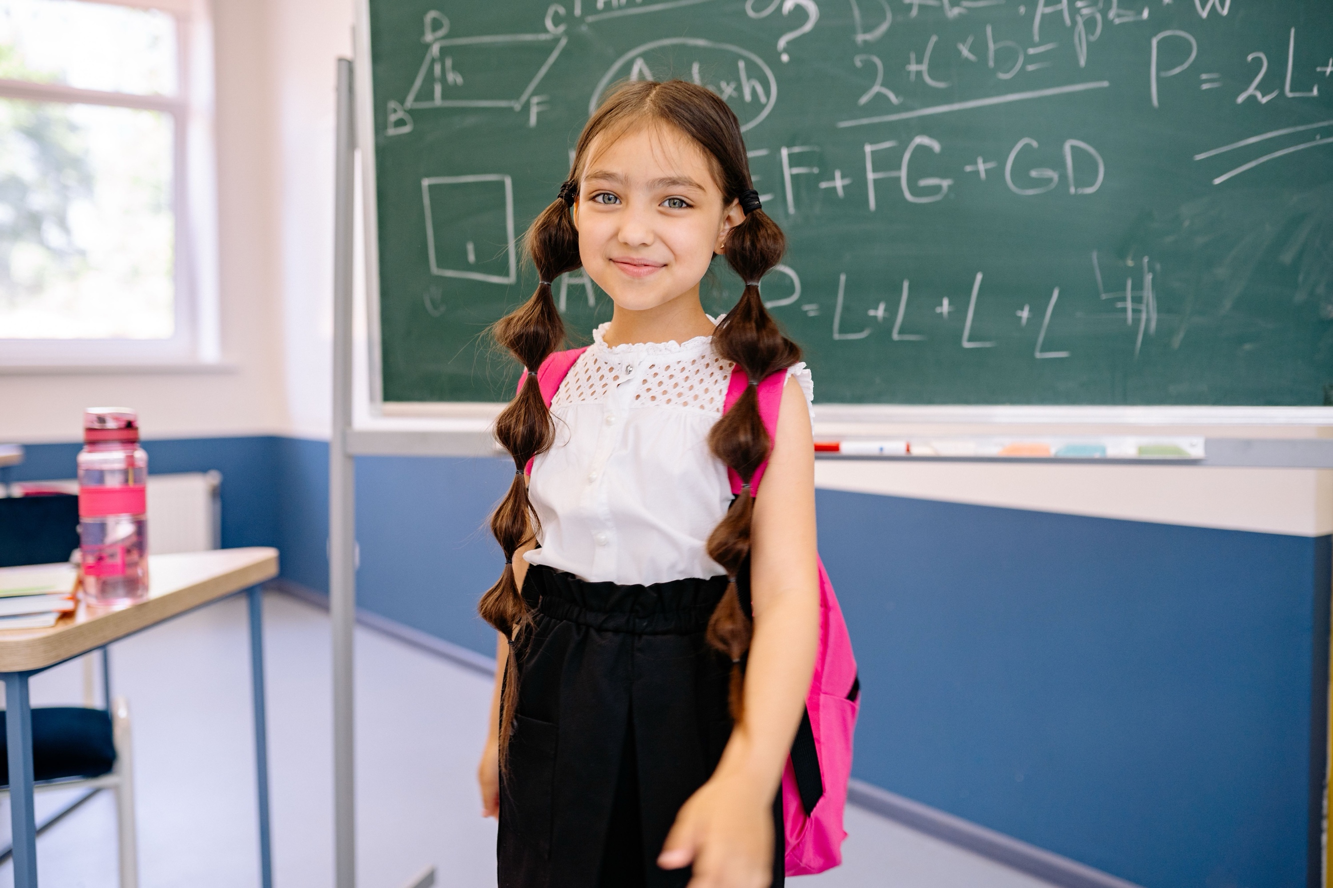 Little girl with a pink backpack smiling